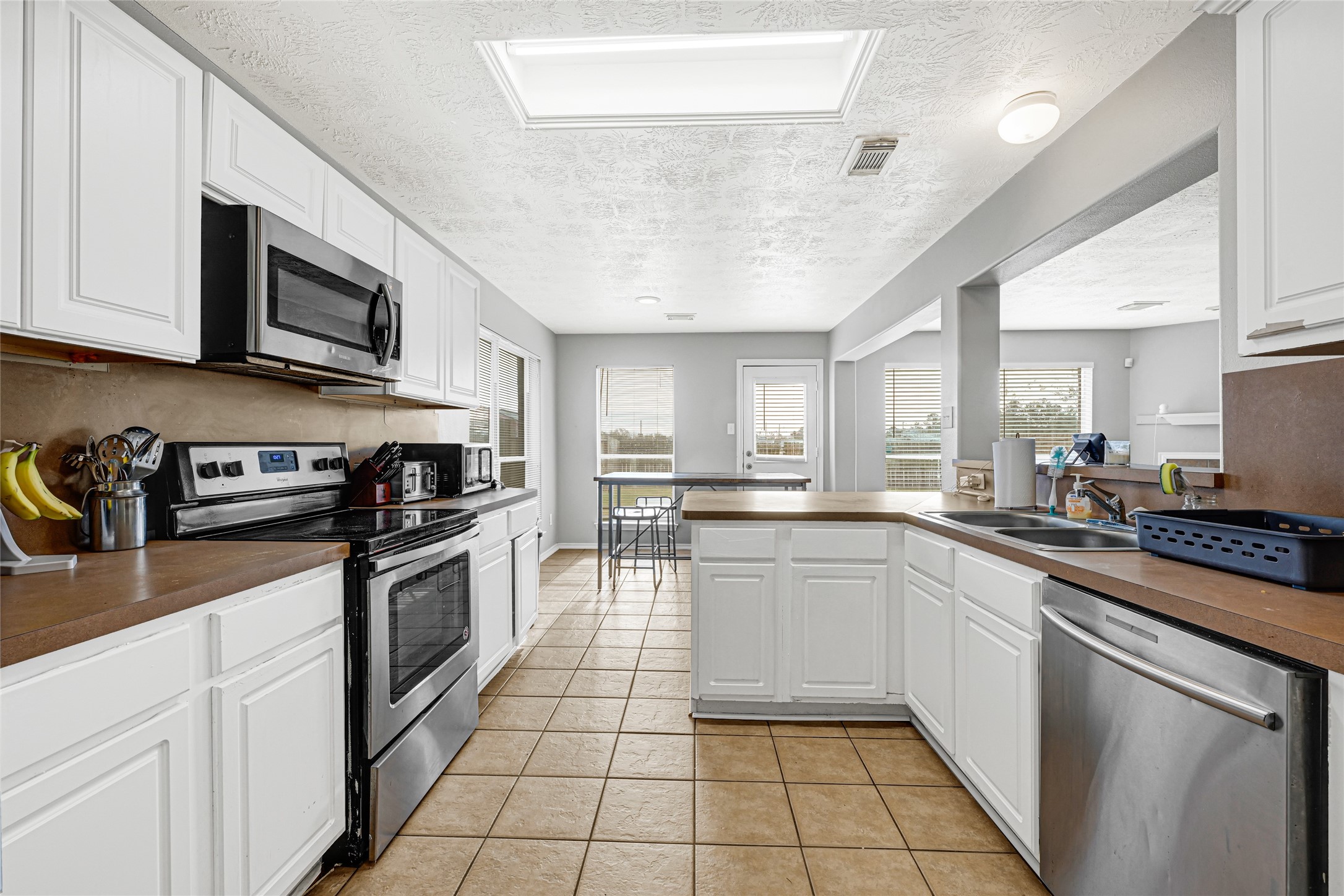 5707 Meadow Breeze Lane Rosharon, TX 77583 - Photo 13 of 26 a kitchen with stainless steel appliances granite countertop a sink and stove top oven