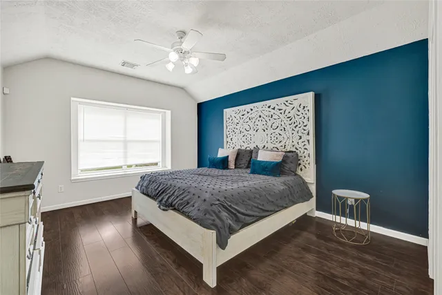 a bedroom with a large bed chandelier and a window