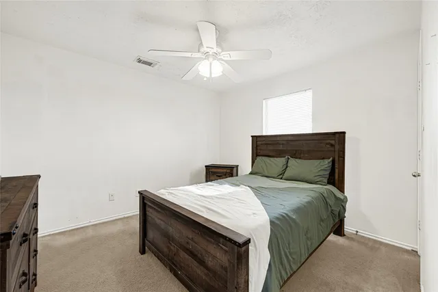 a bedroom with a bed and a chandelier fan