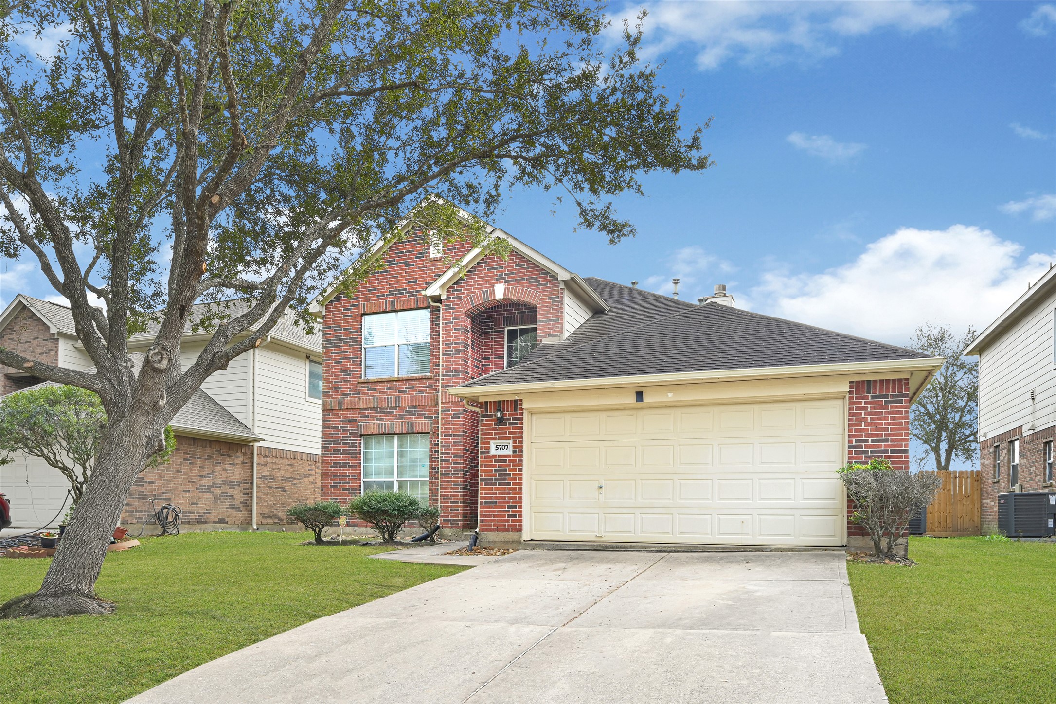 5707 Meadow Breeze Lane Rosharon, TX 77583 - Photo 2 of 26 a front view of a house with a garden and trees