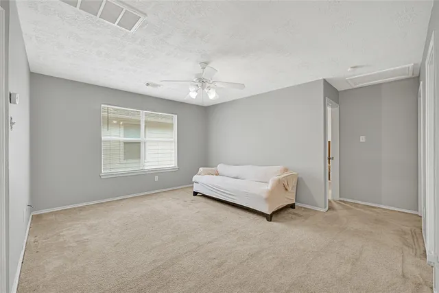 an empty room with windows and ceiling fan