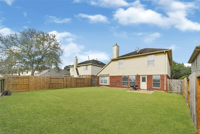 a view of a house with a backyard and a patio