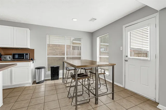 a kitchen with stainless steel appliances kitchen island granite countertop a table and chairs in it