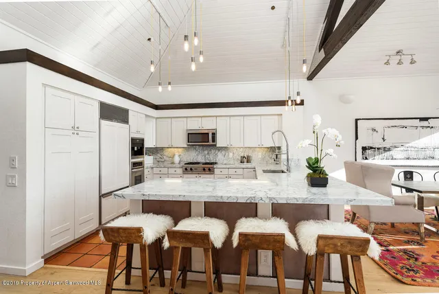 a large kitchen with a table chairs refrigerator and microwave