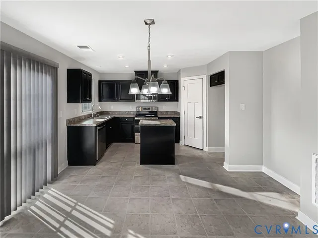 a kitchen with stainless steel appliances granite countertop a refrigerator a sink and a stove