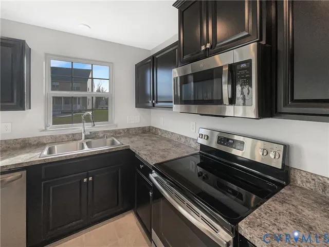 a kitchen with a sink stove and microwave