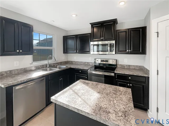 a kitchen with a sink stove top oven and microwave