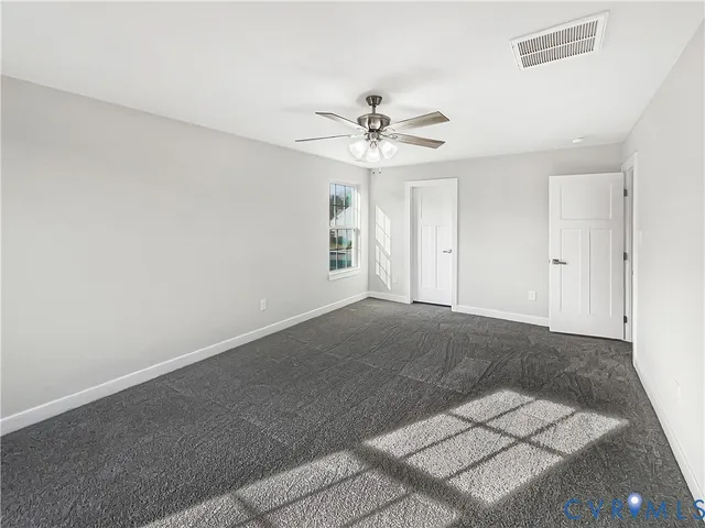 a view of a big room with chandelier fan and windows