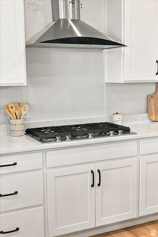 754 West 400 North Mapleton, UT 84664 - Photo 19 of 86 Stainless steel range hood, built-in gas cooktop, quartz-finish countertops, white shaker cabinetry, and matte black hardware.