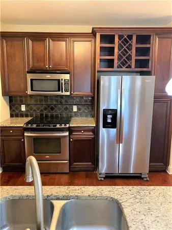 a kitchen with granite countertop wooden cabinets and a stainless steel appliances