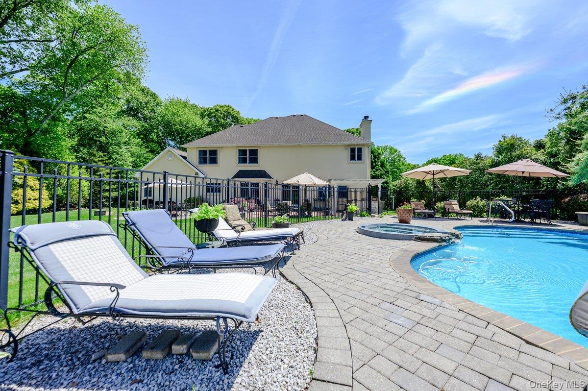 129 Round Swamp Road Huntington, NY 11743 - Photo 44 of 49 Expansive backyard featuring a large swimming pool with integrated spa, paver patio, and black wrought iron fencing