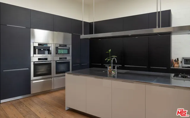 a kitchen with stainless steel appliances a sink and a refrigerator