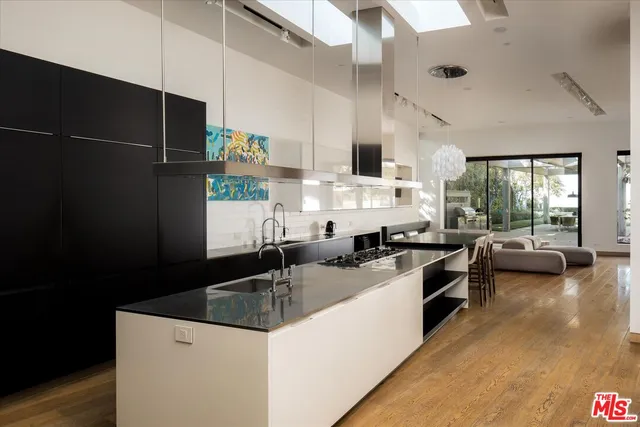 a kitchen with granite countertop a sink a stove and refrigerator