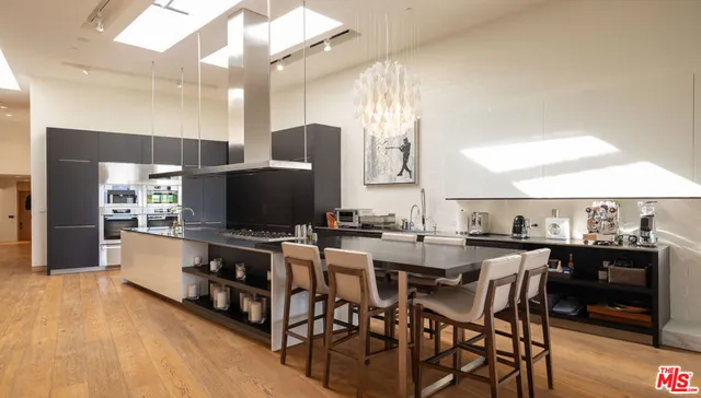 a kitchen with stainless steel appliances a table and chairs in it