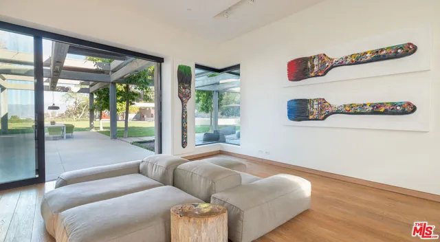 a living room with furniture and a floor to ceiling window