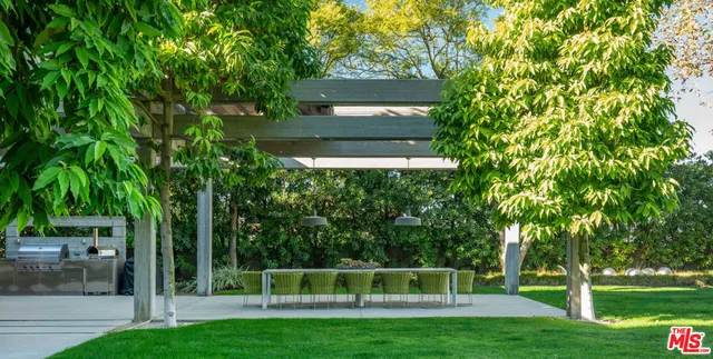 a view of yard with green space and trees in the background