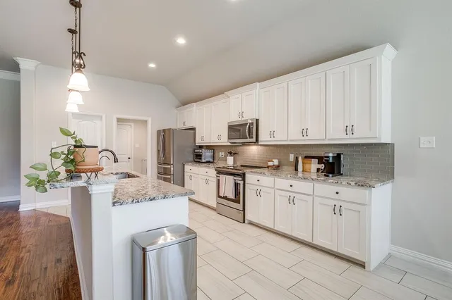 a dining room with furniture a potted plant and a chandelier