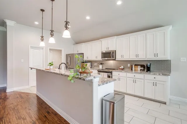 a kitchen with kitchen island a sink stainless steel appliances and cabinets