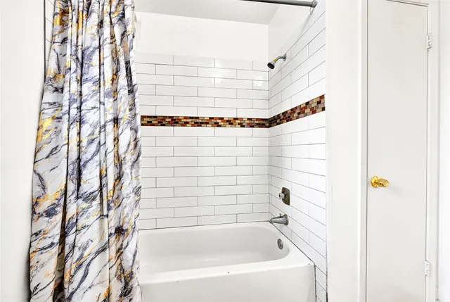 a bathroom with a bathtub and shower