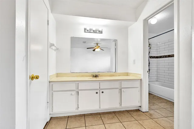 a bathroom with a granite countertop sink a mirror and a shower