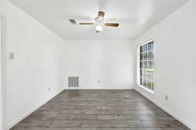 a view of empty room with wooden floor