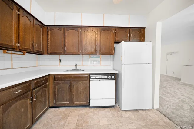 a kitchen with a refrigerator sink and cabinets