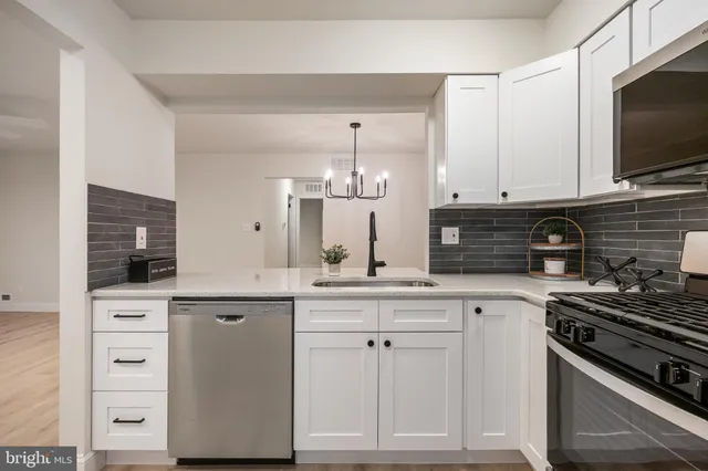 a kitchen with white cabinets and appliances