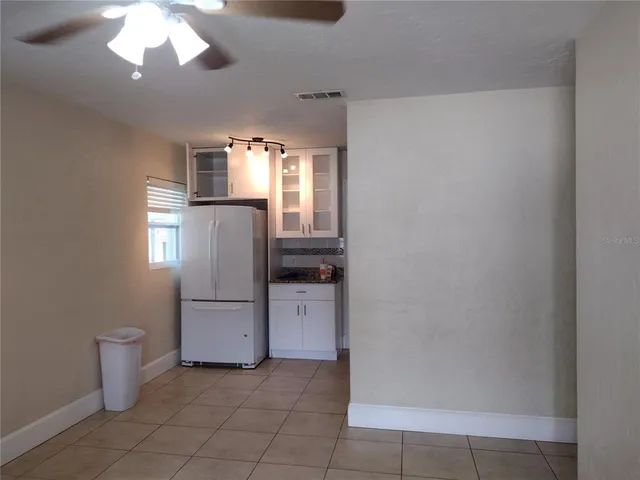 a view of a kitchen with a refrigerator a ceiling fan and wooden floor