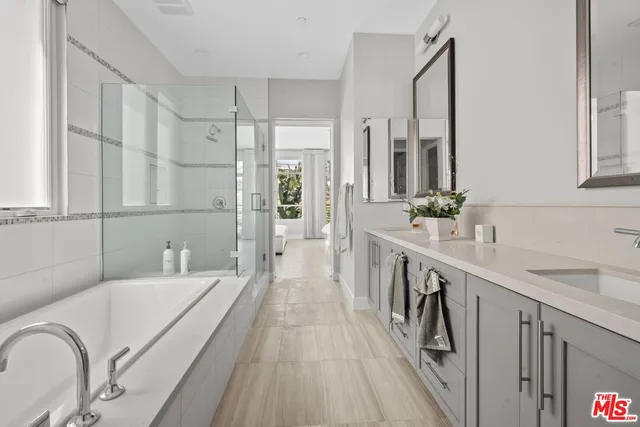 a bathroom with a double vanity sink a mirror and a shower