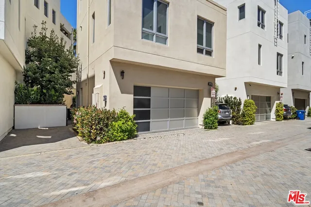 a view of a house with potted plants and a garage