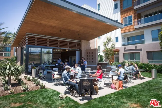 a view of a chairs and tables in the patio and a backyard