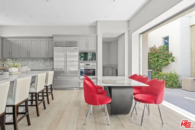 a view of kitchen with stainless steel appliances kitchen island dining table and chairs