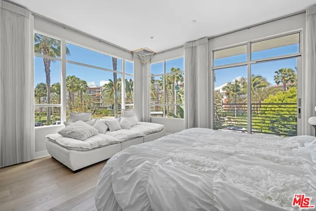 a spacious bedroom with a bed and a couch next to a window