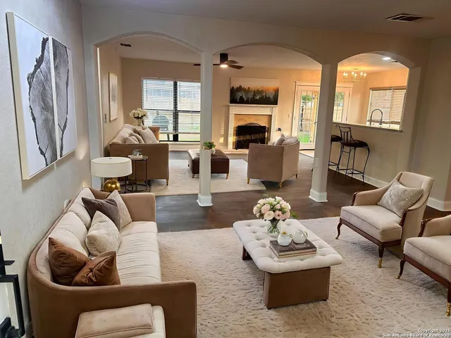 a living room with furniture fireplace and a large window