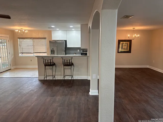 a view of a kitchen with furniture and wooden floor