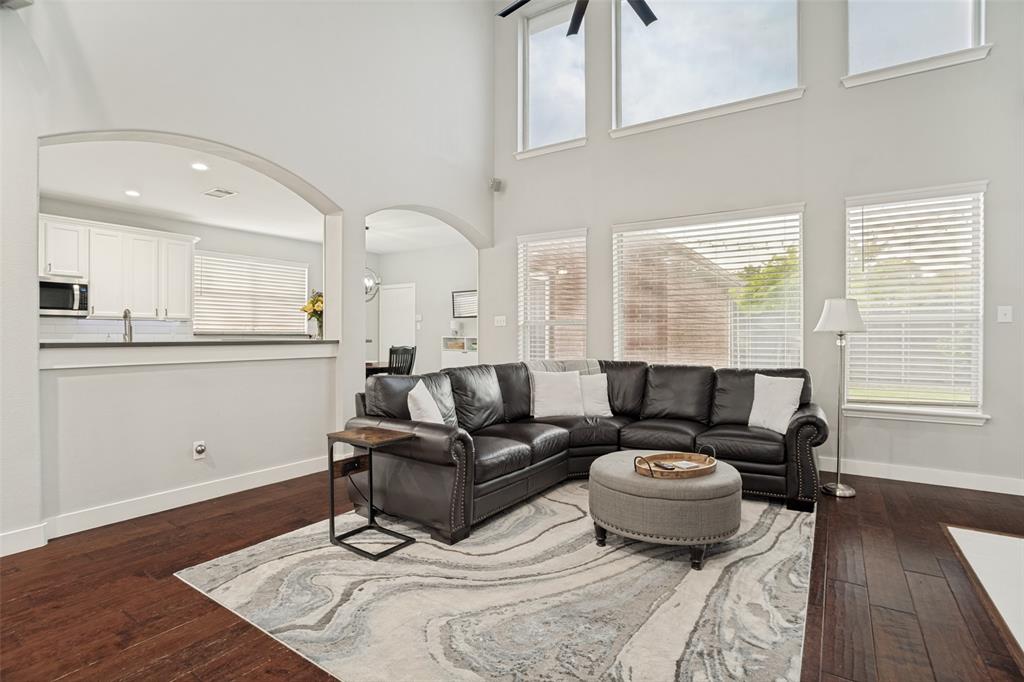 1612 Coventry Lane Allen, TX 75002 - Photo 21 of 39 Spacious living area featuring wood-finish flooring, high ceilings, and multiple windows