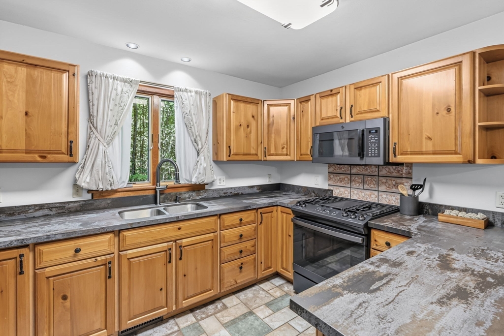 345 Harvey Road Worthington, MA 01098 - Photo 16 of 41 a kitchen with kitchen island granite countertop a sink cabinets and window