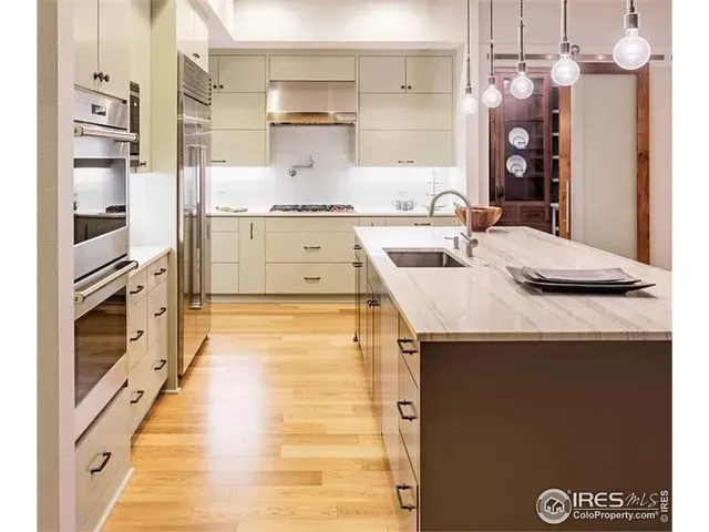 a large kitchen with stainless steel appliances kitchen island granite countertop a sink and cabinets