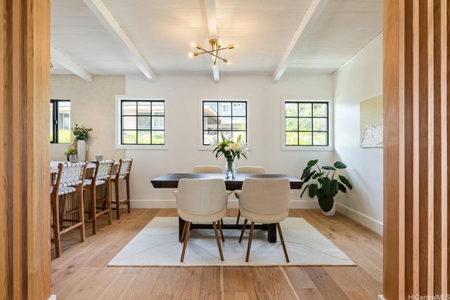 a dining room with wooden floor a chandelier a wooden table and chairs