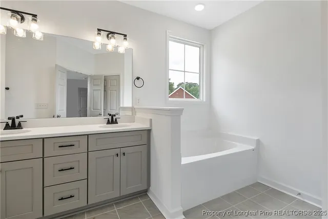 a spacious bathroom with a double vanity sink a mirror and a shower