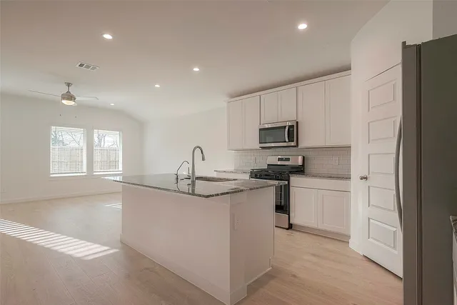 a kitchen with stainless steel appliances granite countertop a sink stove and refrigerator