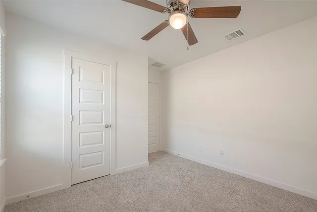 an empty room with a fan and a fan