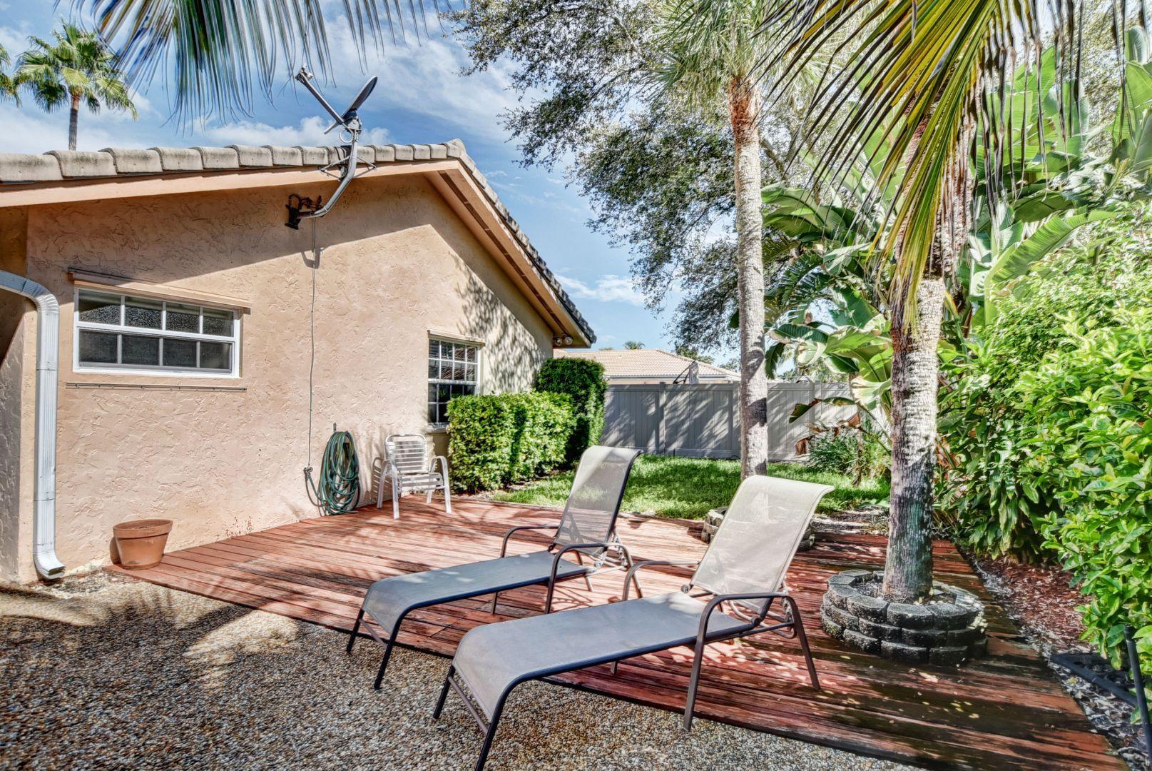 2068 Southwest 8th Avenue Boca Raton, FL 33486 - Photo 28 of 35 a backyard of a house with table and chairs