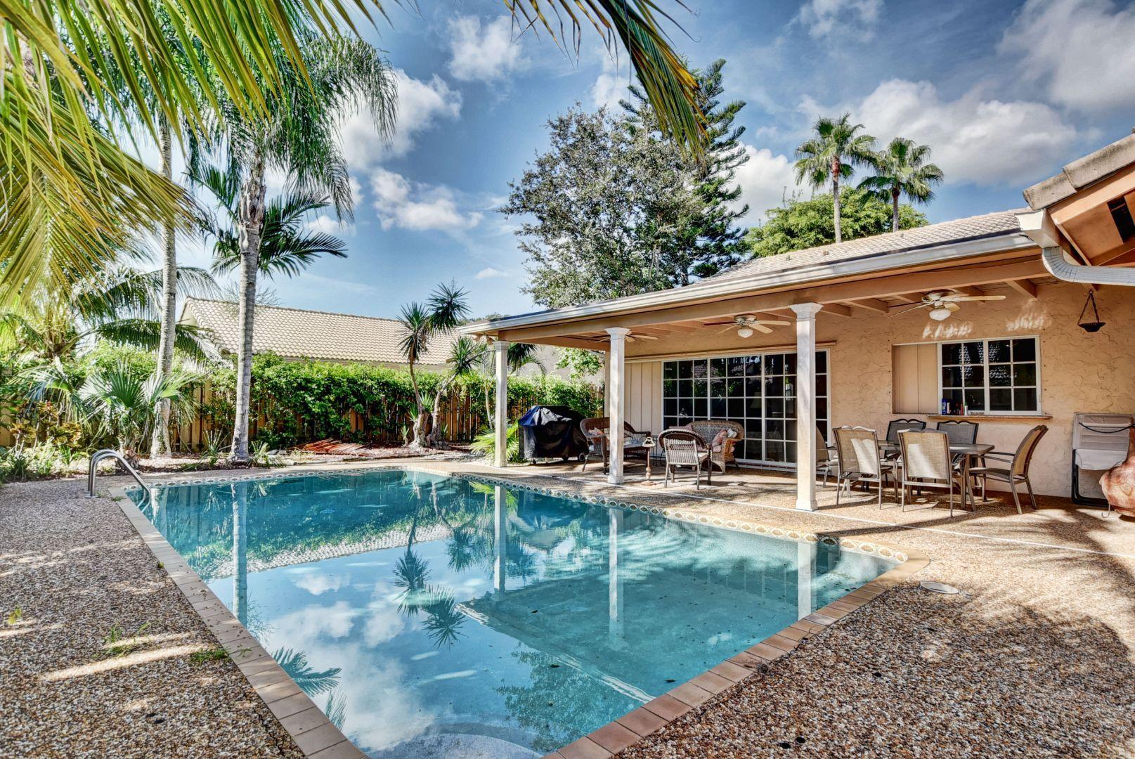 2068 Southwest 8th Avenue Boca Raton, FL 33486 - Photo 29 of 35 a view of a house with backyard sitting area and swimming pool
