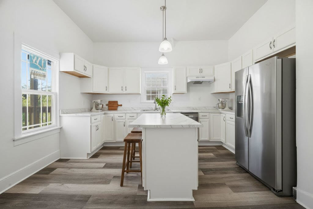 8919 South Exchange Avenue Chicago, IL 60617 - Photo 14 of 41 a kitchen with kitchen island white cabinets and stainless steel appliances