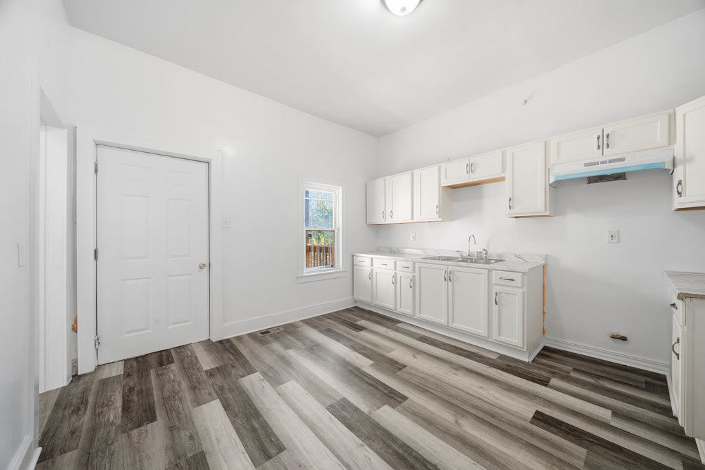 8919 South Exchange Avenue Chicago, IL 60617 - Photo 15 of 41 a view of a kitchen with white cabinets and wooden floor