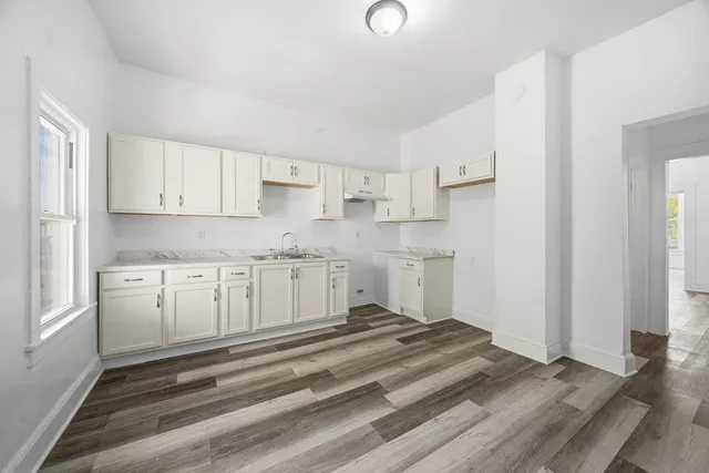 a kitchen with granite countertop white cabinets and white appliances