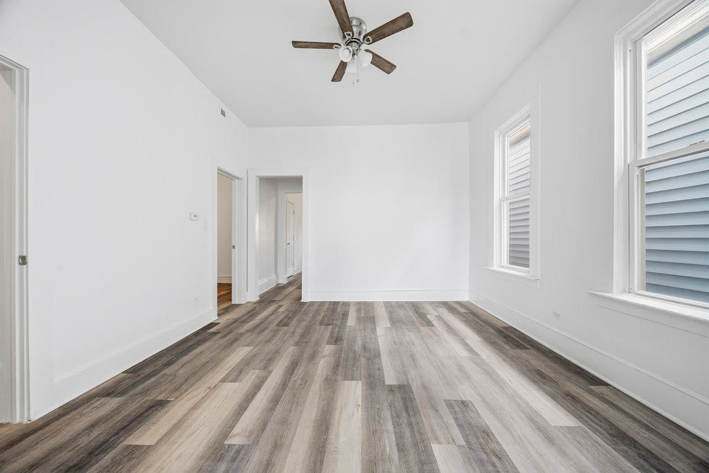 8919 South Exchange Avenue Chicago, IL 60617 - Photo 21 of 41 wooden floor in an empty room with a window