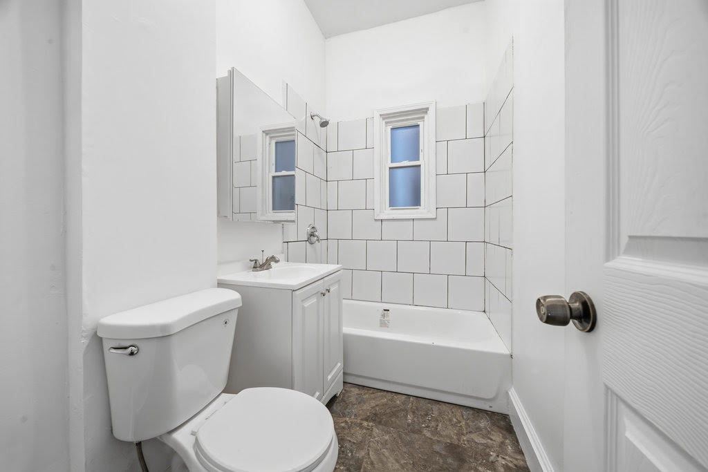8919 South Exchange Avenue Chicago, IL 60617 - Photo 25 of 41 a white toilet sitting next to a white bath tub