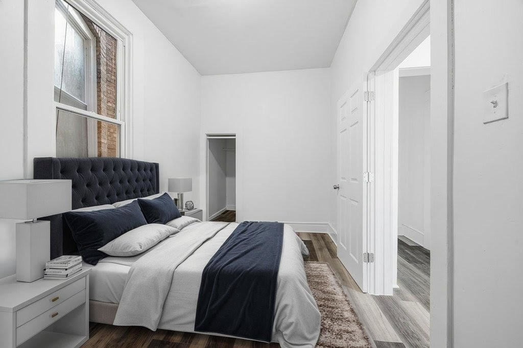 8919 South Exchange Avenue Chicago, IL 60617 - Photo 29 of 41 a bedroom with a bed and a window